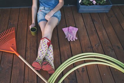 Mom sitting on her deck resting during gardening, having a cuppa - instead of a mom's night out