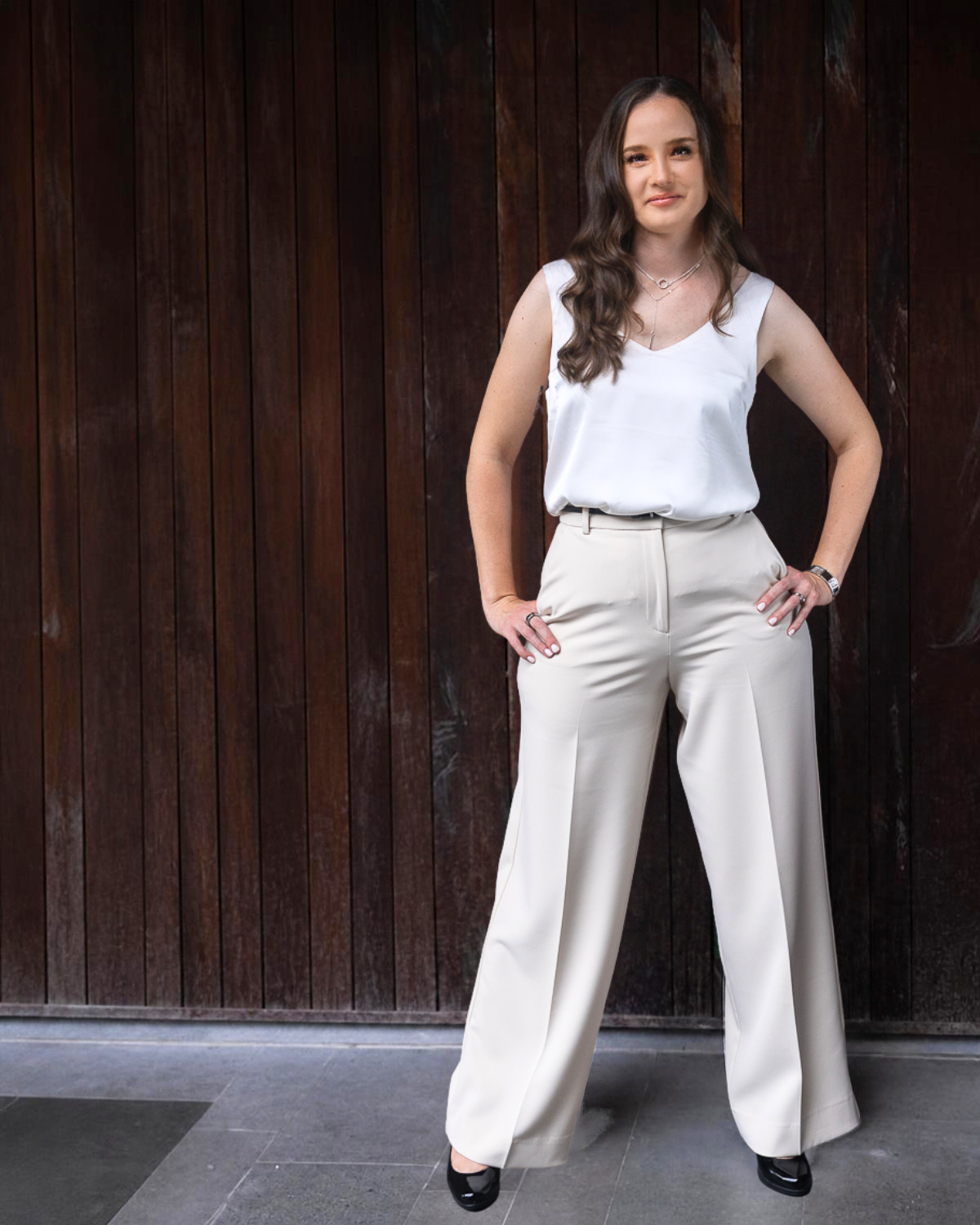 Abigail Burton standing against a dark timber background